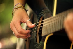 Girl playing fingerstyle guitar